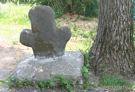 Похоже на крест, но это - каменная баба в позе "знамения", из которой пытались сделать крест. Стоит во дворе Козельского краеведческого музея
