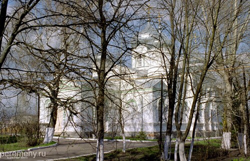 За деревьями Успенский храм Параскево-Возненсенского монастыря