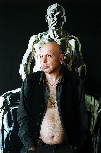 Игорь Дудинский на фоне своего портрета работы Ивана Новоженова. Фото: Михаил Геллер