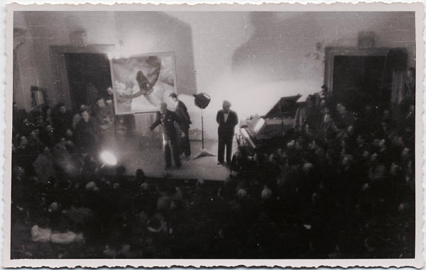 Это уже позже, в 20-е годы. Маринетти (у микрофона) демонстрирует "Аэроживопись" (см. Википедию) - на сцене картина Туллио Карли
